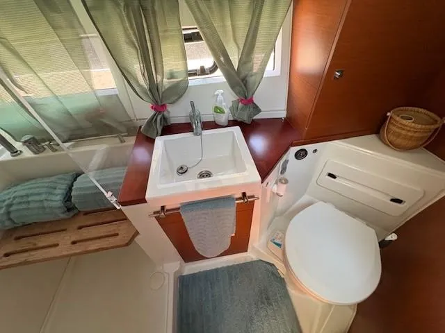Slide: The Image of Bathroom interior of 2013 Jeanneau NC11 boat with sink, toilet, and window. - 15