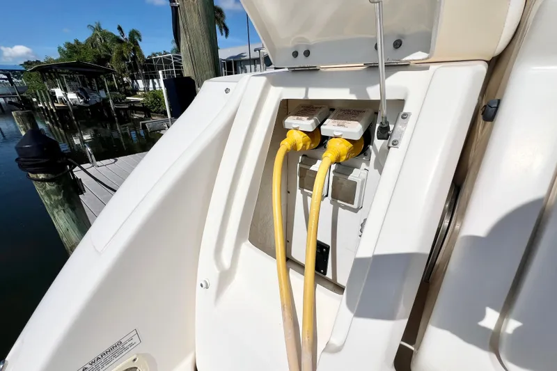 Slide: The Image of 2012 Sea Ray 310 Sundancer power connections at dockside, featuring yellow cables. - 11
