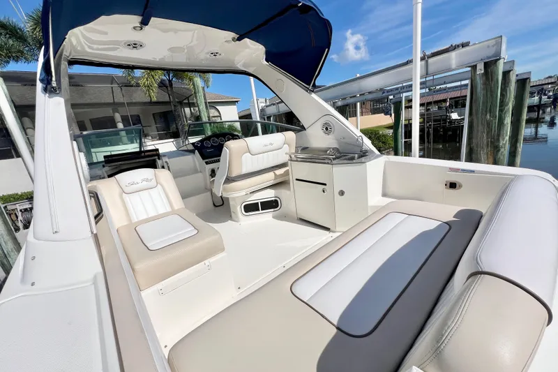 Slide: The Image of 2012 Sea Ray 310 Sundancer boat interior with seating and helm, docked by water. - 17