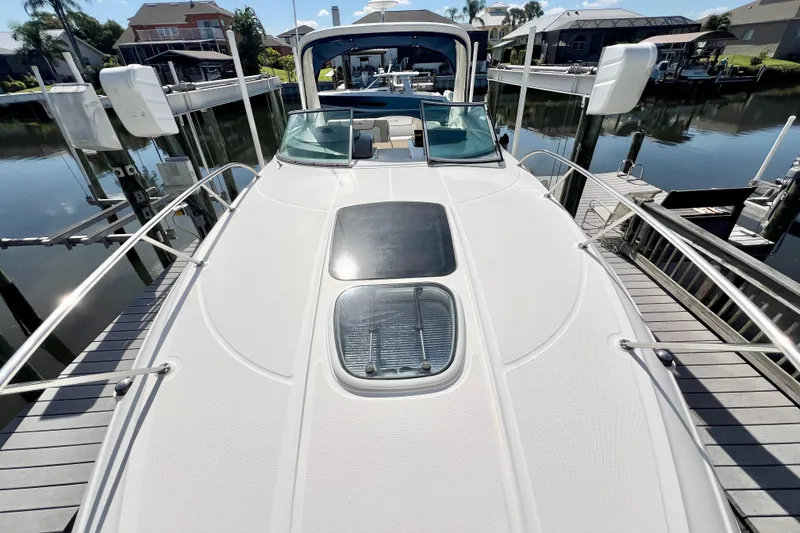 Slide: The Image of 2012 Sea Ray 310 Sundancer yacht docked at marina, showcasing sleek deck design. - 19