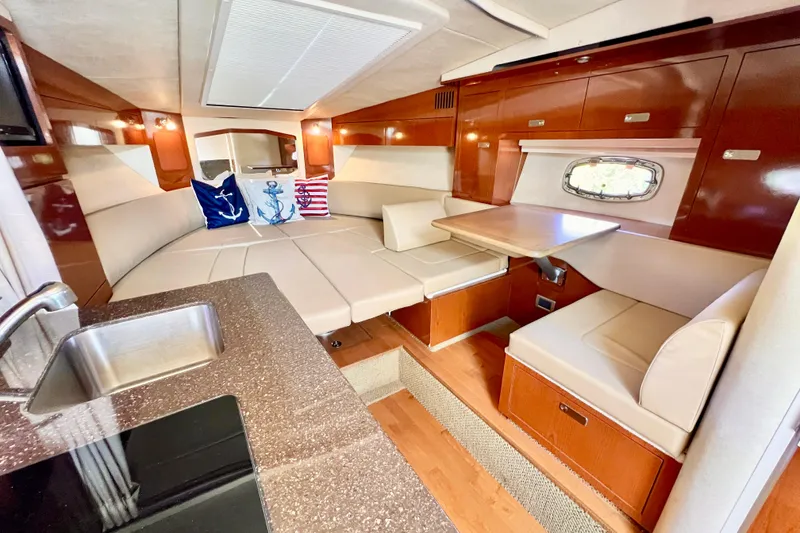 Slide: The Image of Luxurious 2012 Sea Ray 310 Sundancer cabin interior with seating, table, and kitchenette. - 3
