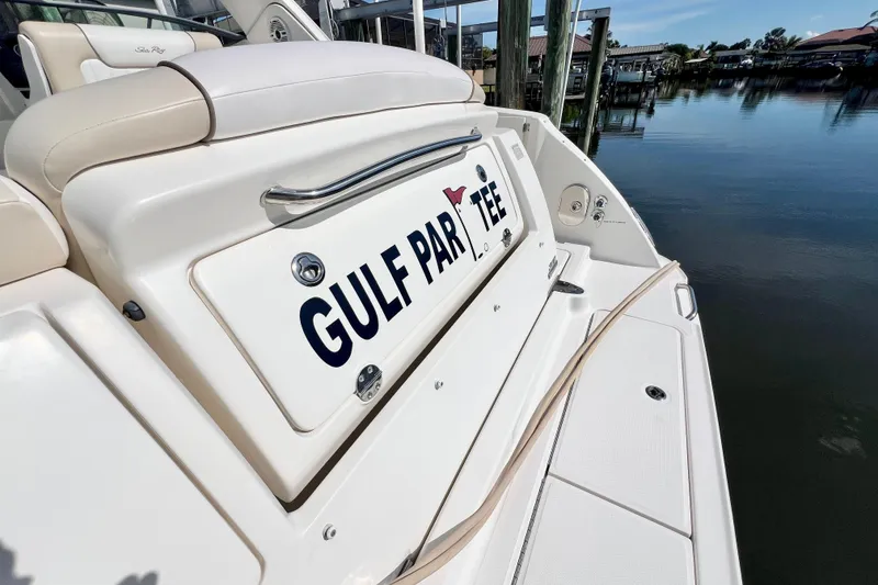 Slide: The Image of 2012 Sea Ray 310 Sundancer boat with "Gulf Par Tee" name, docked by calm waters. - 9