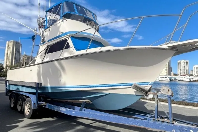 Slide: The Image of 1989 Blackman Billfisher 26 boat on trailer by waterfront, city skyline in background. - 10