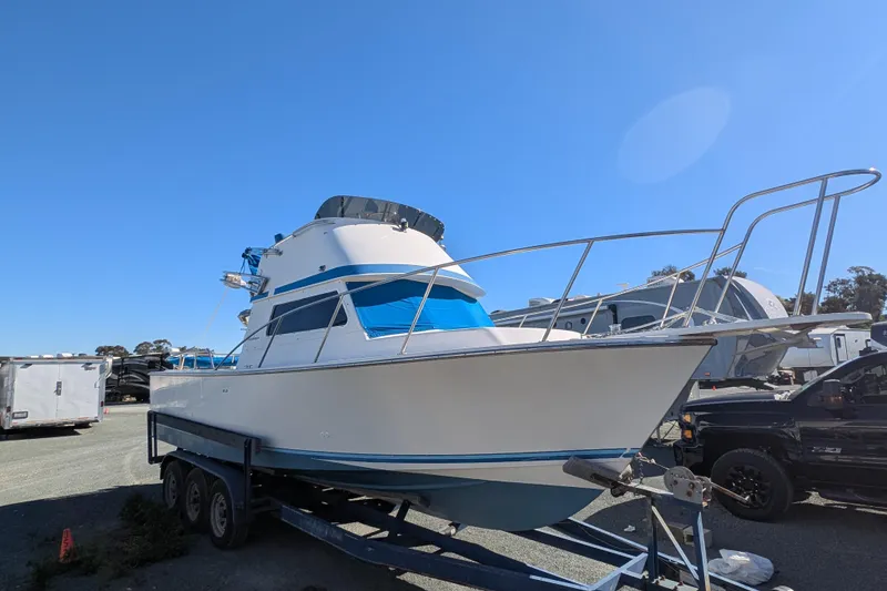 Slide: The Image of 1989 Blackman Billfisher 26 boat on trailer under clear blue sky. - 11