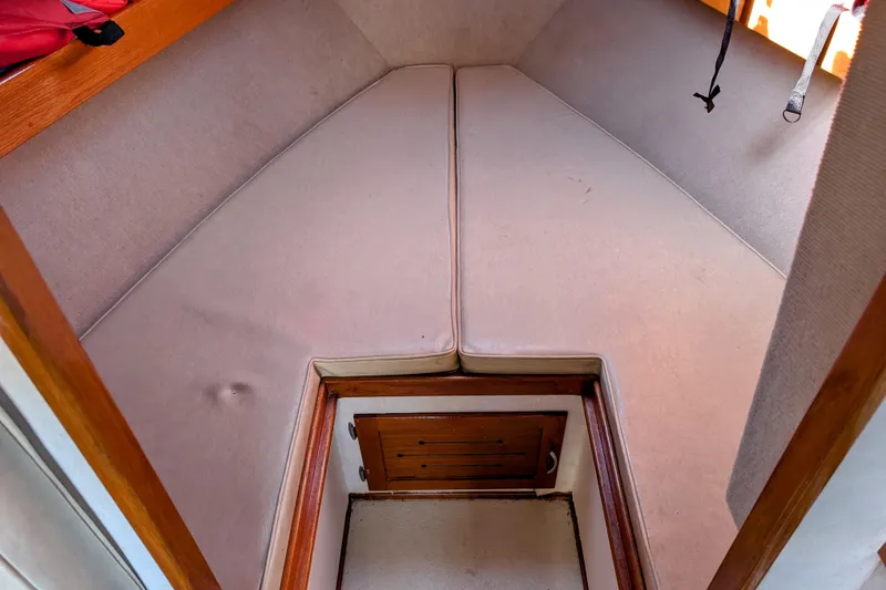 Slide: The Image of 1989 Blackman Billfisher 26 boat cabin interior with cushioned seating and wooden accents. - 16