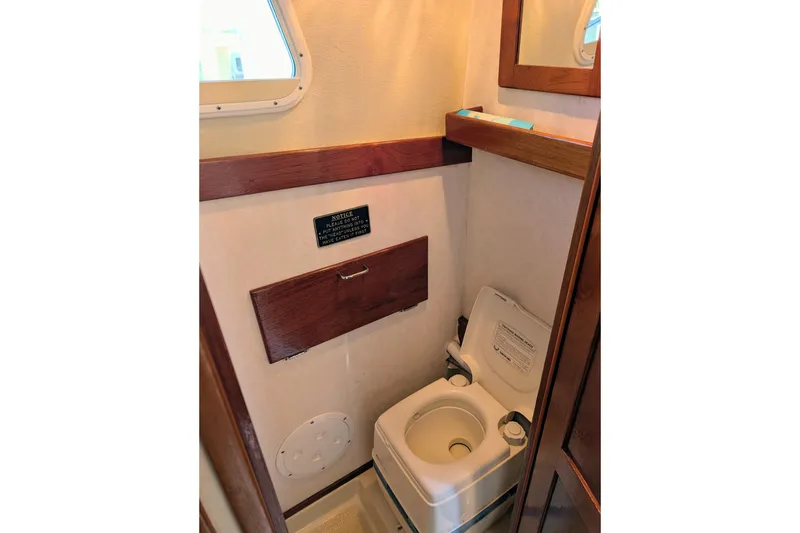 Slide: The Image of 1989 Blackman Billfisher 26 boat bathroom with compact toilet and wooden accents. - 22