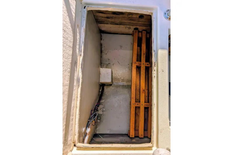 Slide: The Image of Storage compartment of 1989 Blackman Billfisher 26 boat with wooden slats and wiring. - 25