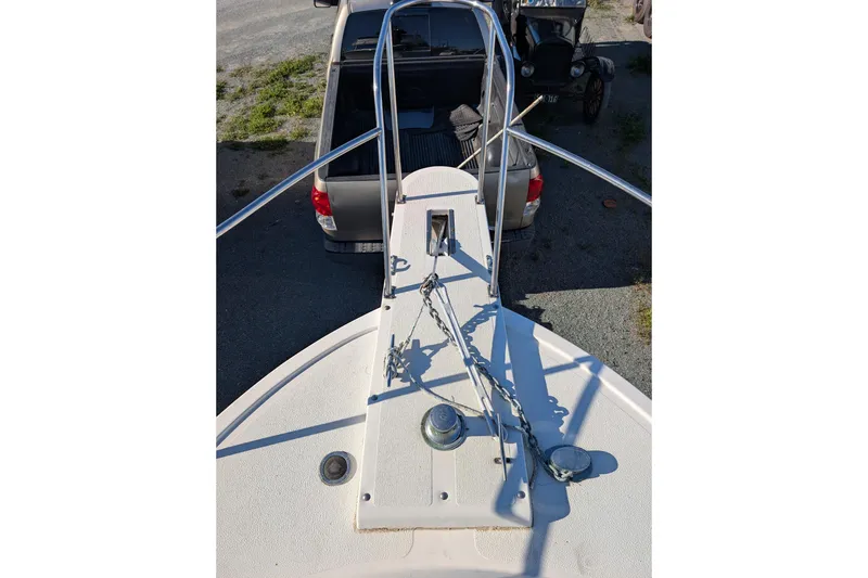 Slide: The Image of 1989 Blackman Billfisher 26 boat bow with anchor chain, parked near a vehicle. - 34