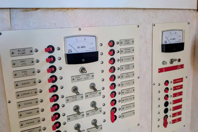 Slide: The Image of Electrical control panel on a 1989 Blackman Billfisher 26 boat, featuring various switches and meters. - 43