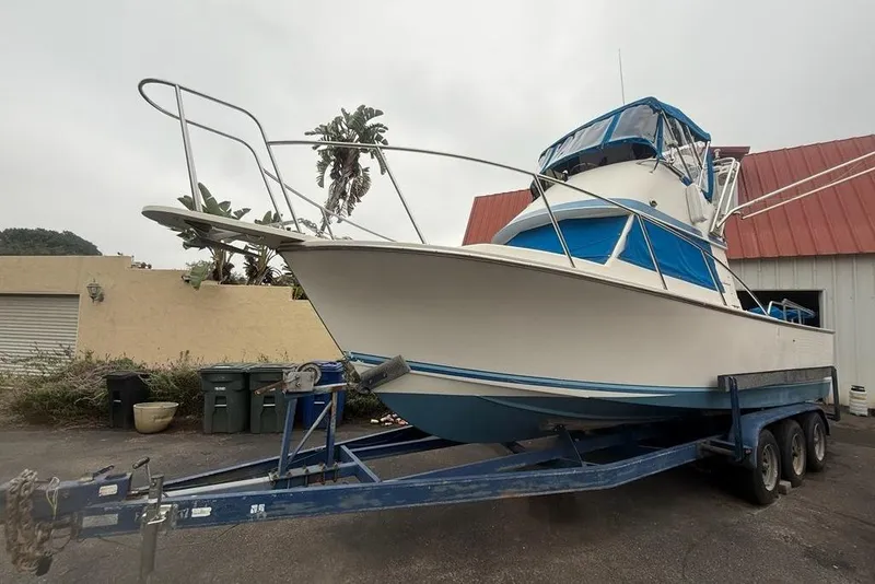 Slide: The Image of 1989 Blackman Billfisher 26 boat on trailer, parked near a building. - 6