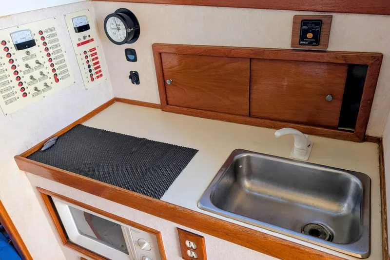 Slide: The Image of 1989 Blackman Billfisher 26 boat interior with sink, control panel, and wooden cabinetry. - 9