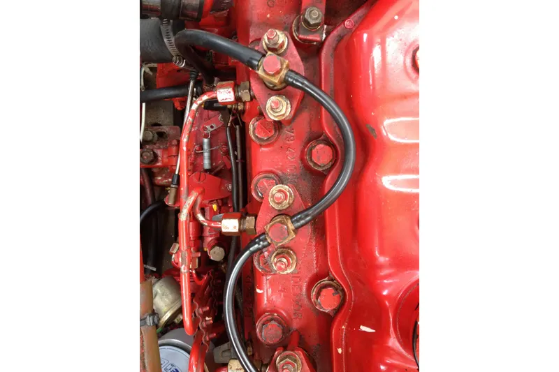 Slide: The Image of Close-up of a red 1958 Atkins Sun Flower 22 engine with visible bolts and wiring. - 12