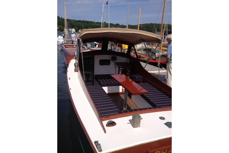 Slide: The Image of 1958 Atkins Sun Flower 22 boat with canopy, docked at marina, showcasing classic design. - 2