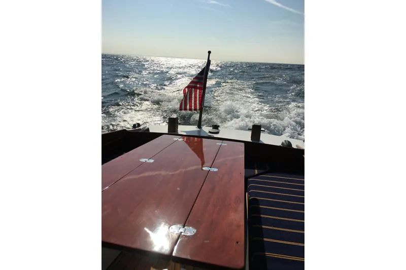 Slide: The Image of Vintage 1958 Atkins Sun Flower 22 boat cruising on open water with American flag. - 3