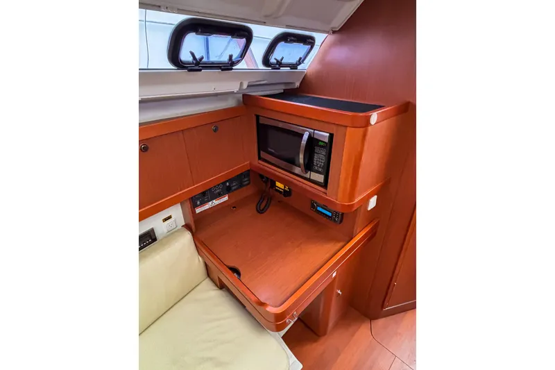Slide: The Image of Interior of 2015 Beneteau Oceanis 37 yacht with microwave and wooden cabinetry. - 14