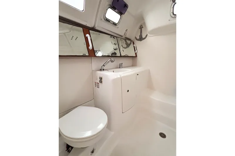Slide: The Image of Bathroom interior of 2015 Beneteau Oceanis 37 yacht, featuring toilet, sink, and mirror. - 3