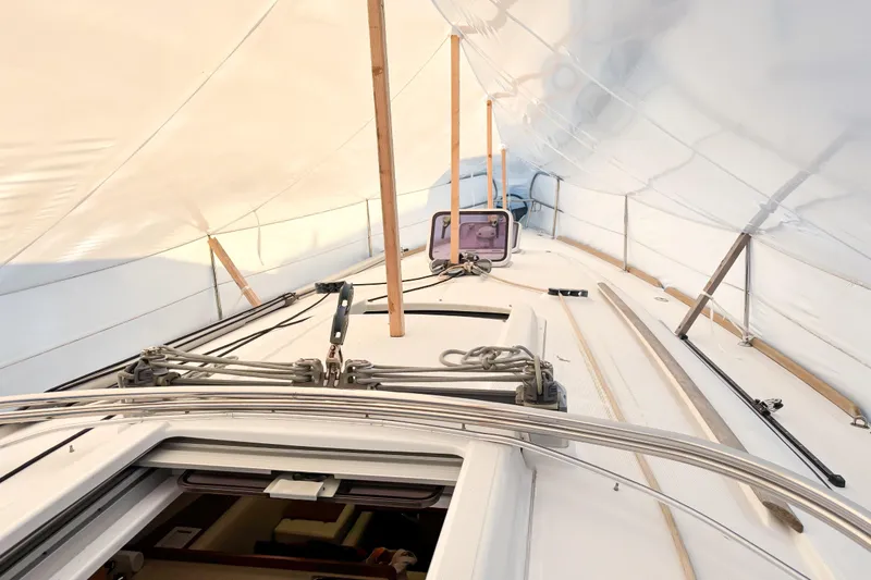 Slide: The Image of 2015 Beneteau Oceanis 37 sailboat deck under protective cover, showcasing rigging and hatch. - 5