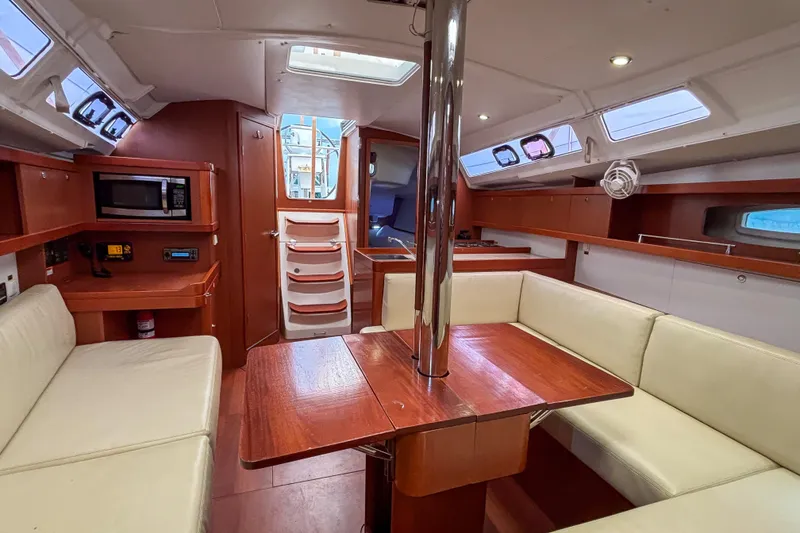 Slide: The Image of Interior of 2015 Beneteau Oceanis 37 sailboat with dining area and kitchenette. - 9