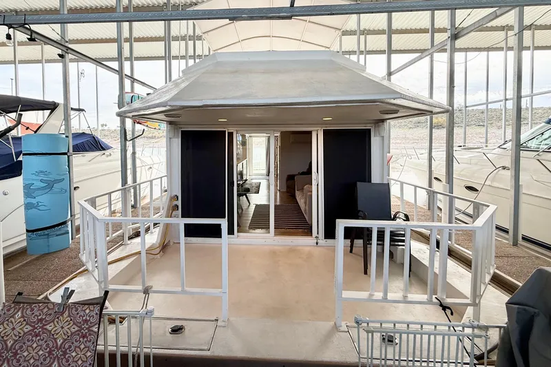 The Image of 1985 Three Buoys 42 Sport Cruiser HB docked, featuring spacious deck and sliding glass doors. - 1