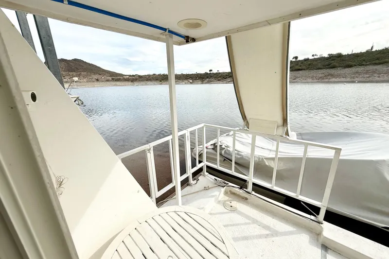 Slide: The Image of 1985 Three Buoys 42 Sport Cruiser HB, deck view overlooking serene lake and hills. - 14