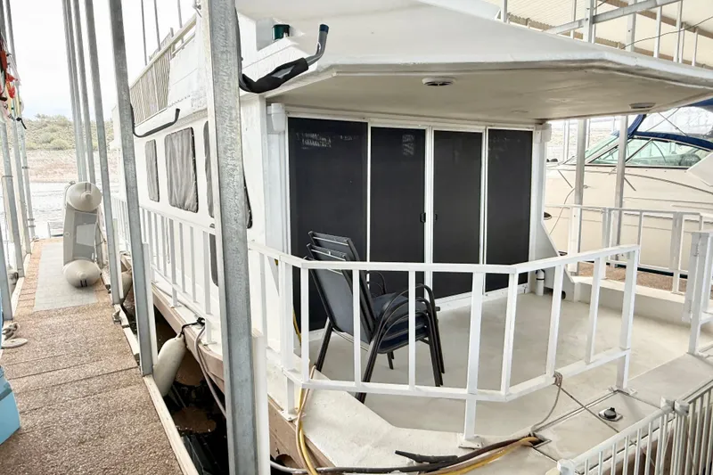 Slide: The Image of 1985 Three Buoys 42 Sport Cruiser HB docked, featuring spacious deck and seating area. - 18