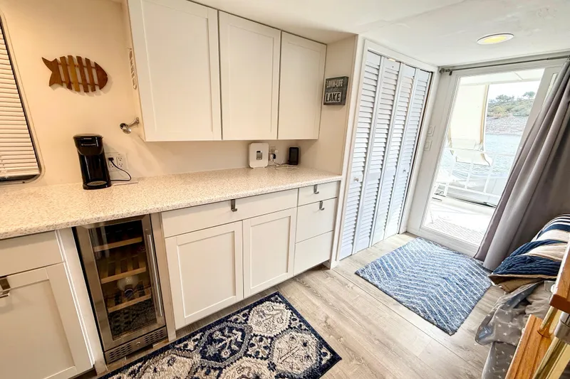 Slide: The Image of Modern kitchen interior on 1985 Three Buoys 42 Sport Cruiser HB, featuring white cabinets and lake view. - 6