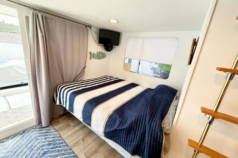 Slide: The Image of Cozy bedroom in 1985 Three Buoys 42 Sport Cruiser HB with striped bedding and lake view. - 7