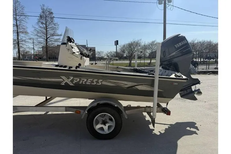 Slide: The Image of 2009 Express HD20 boat on trailer with Yamaha outboard motor, parked outdoors. - 4