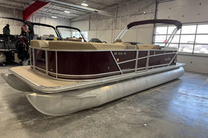 The Image of 2022 SunChaser Geneva Cruise 24 CRS pontoon boat in a showroom setting. - 1