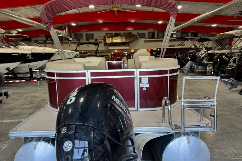 Slide: The Image of 2022 SunChaser Geneva Cruise 24 CRS pontoon boat in showroom with Mercury outboard motor. - 7