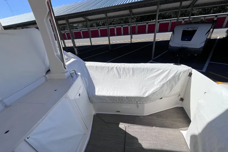 Slide: The Image of 2019 Regal 33 SAV boat interior with covered seating in a parking area. - 12