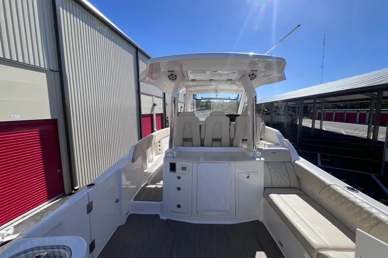 Slide: The Image of 2019 Regal 33 SAV boat interior with seating and storage, docked under clear sky. - 18