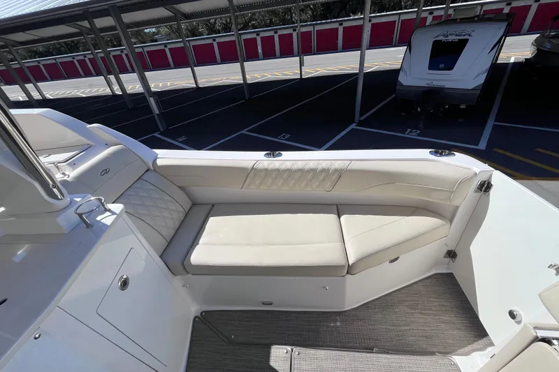 Slide: The Image of 2019 Regal 33 SAV boat interior with beige seating in a covered parking area. - 19
