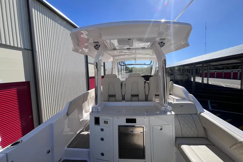 Slide: The Image of 2019 Regal 33 SAV boat interior with seating and storage, docked under clear blue sky. - 21