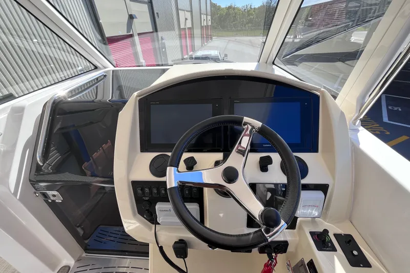 Slide: The Image of 2019 Regal 33 SAV boat helm with steering wheel and dual displays. - 26