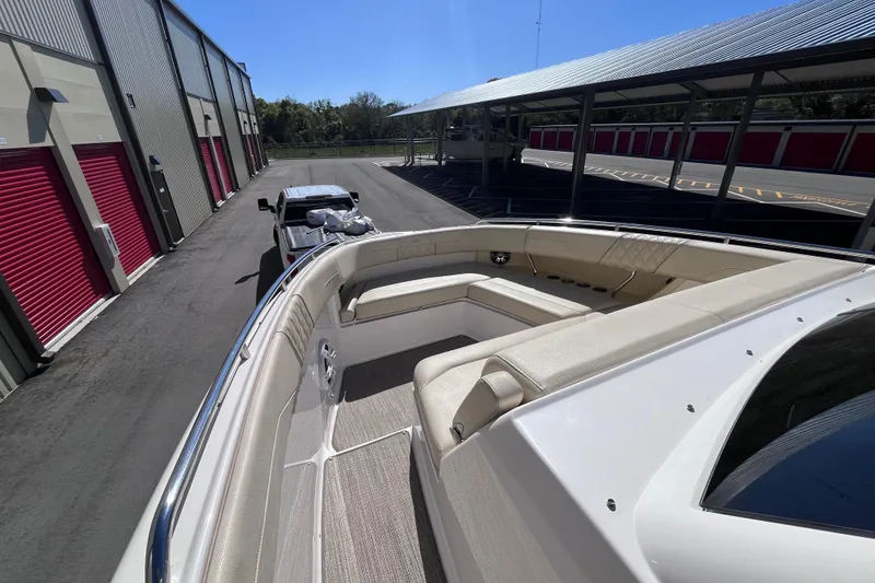 Slide: The Image of 2019 Regal 33 SAV boat with spacious seating, parked near storage units. - 30