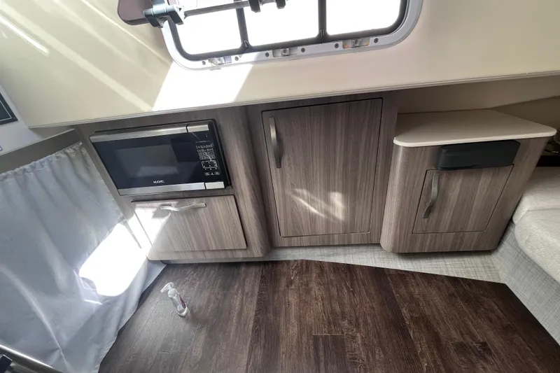Slide: The Image of 2019 Regal 33 SAV interior with microwave, cabinets, and wood flooring. - 37