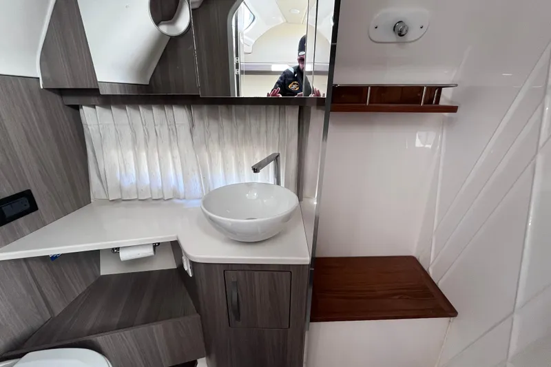Slide: The Image of Modern bathroom interior of 2019 Regal 33 SAV boat with sleek sink and wood accents. - 39