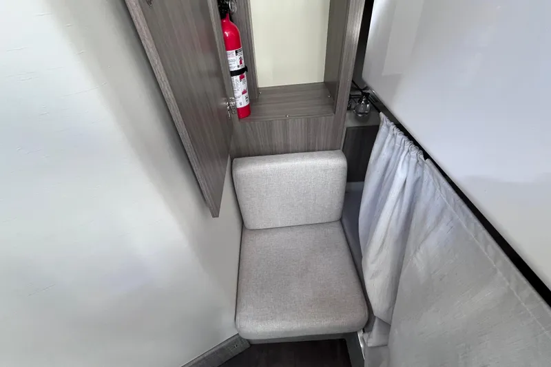 Slide: The Image of Compact seating area with fire extinguisher in 2019 Regal 33 SAV boat interior. - 42