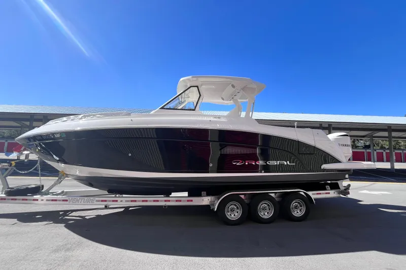 Slide: The Image of 2019 Regal 33 SAV boat on trailer under clear blue sky. - 5