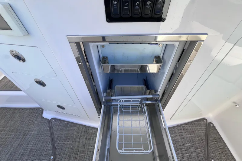 Slide: The Image of 2019 Regal 33 SAV boat interior with open stainless steel drawer and control panel. - 54