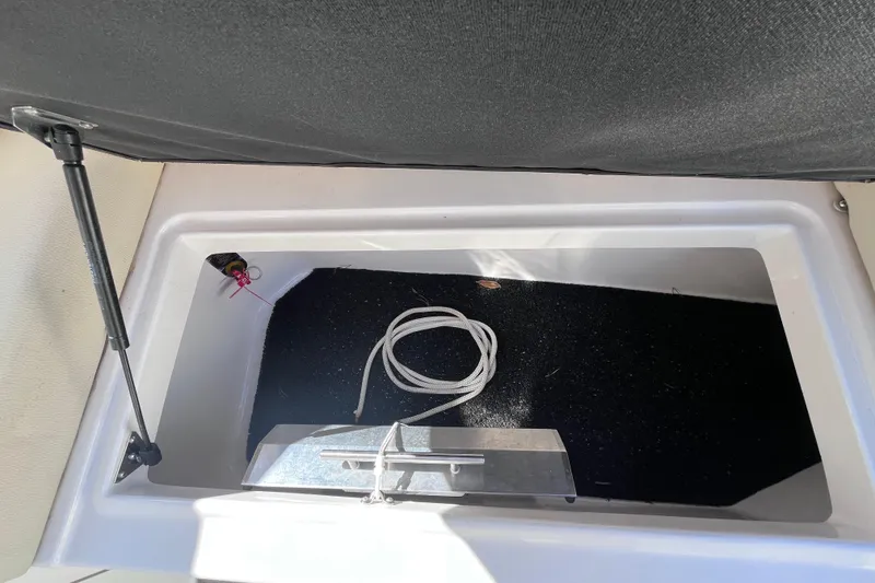 Slide: The Image of Open storage compartment in 2019 Regal 33 SAV boat with coiled rope inside. - 55