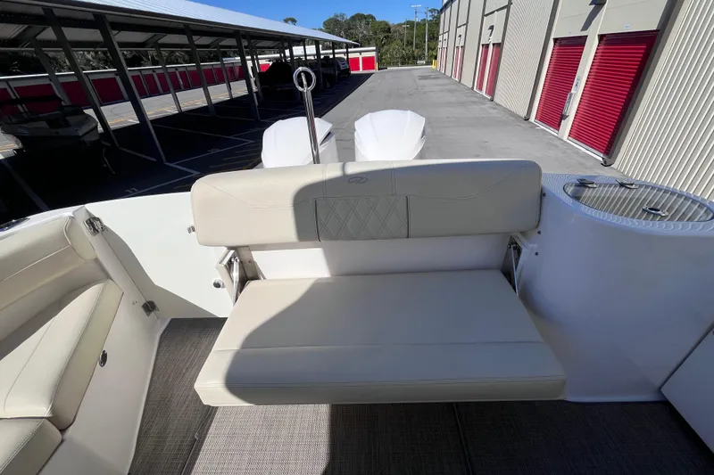 Slide: The Image of 2019 Regal 33 SAV boat interior with beige seating and storage area. - 64