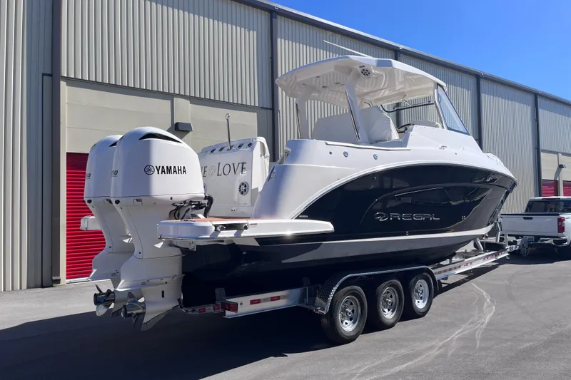 Slide: The Image of 2019 Regal 33 SAV boat on trailer with Yamaha engines, parked outside. - 7