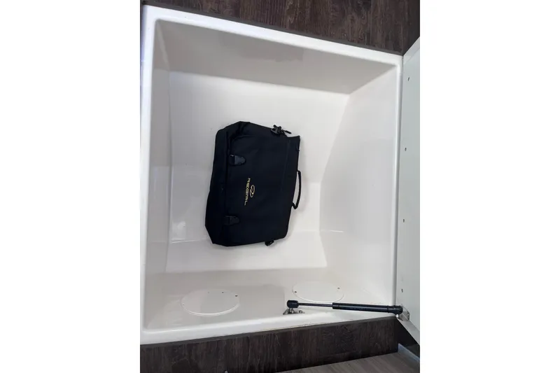 Slide: The Image of Storage compartment of 2019 Regal 33 SAV boat with a black bag inside. - 71