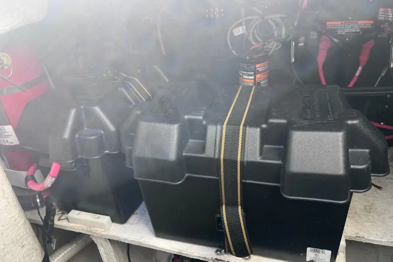 Slide: The Image of Battery compartment of a 2019 Regal 33 SAV boat with secured black battery boxes. - 84