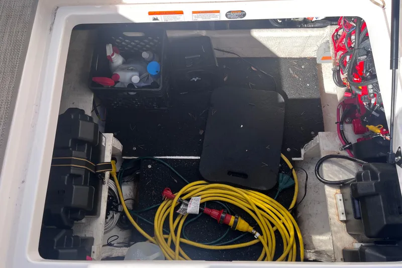 Slide: The Image of Storage compartment of a 2019 Regal 33 SAV boat with cables and cleaning supplies. - 85
