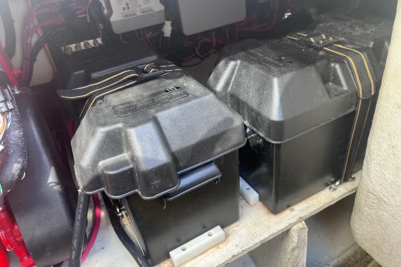 Slide: The Image of Battery compartment of a 2019 Regal 33 SAV boat, featuring secured black battery boxes. - 87