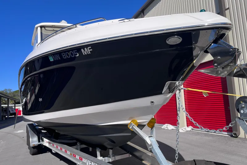 Slide: The Image of 2019 Regal 33 SAV boat on trailer, parked near red storage units. - 9