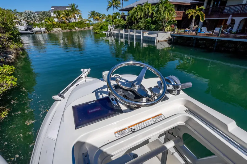 Slide: The Image of 2017 SeaVee 270Z boat steering console in a tropical canal setting. - 25